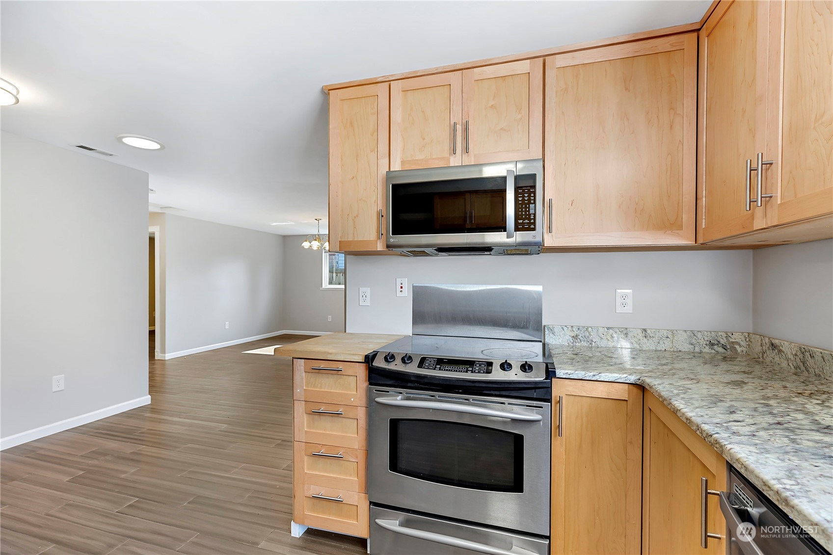 7209 6th Avenue West Everett, WA 98203 - Photo 6 of 27 a kitchen with granite countertop cabinets stainless steel appliances and wooden floor