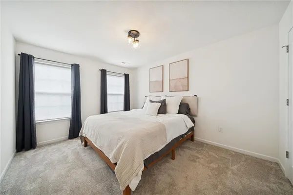 a spacious bedroom with a bed and a window