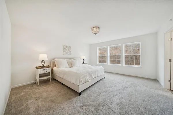 a spacious bedroom with a bed and a large window