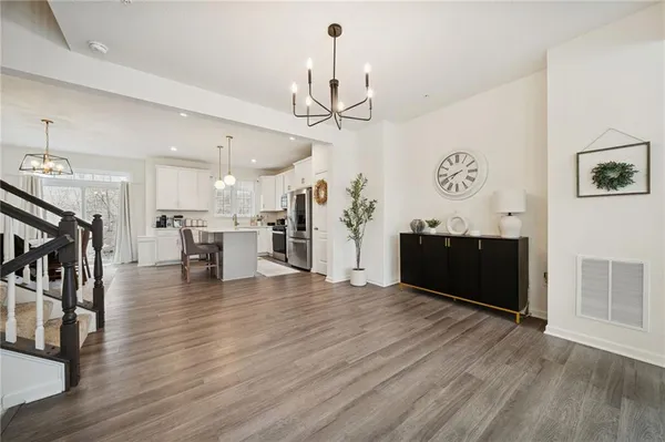 a view of a livingroom with furniture wooden floor and a kitchen