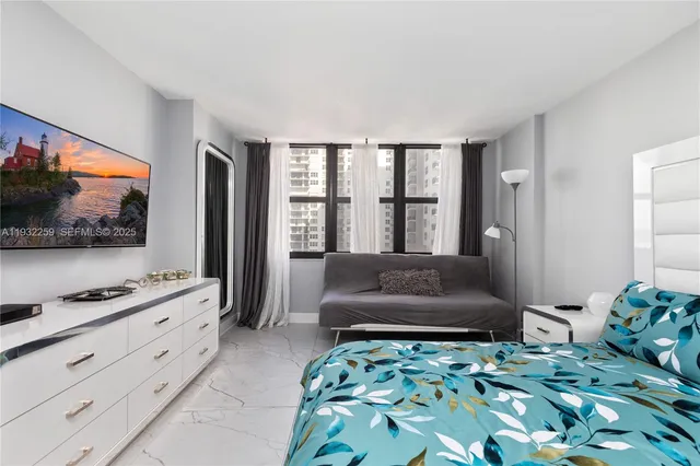 a bedroom with a bed and a flat screen tv