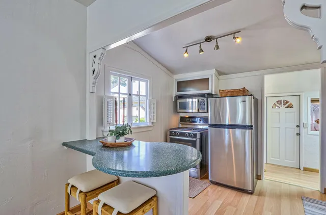 a kitchen with sink refrigerator dining table and wooden floor