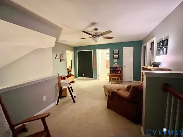 a living room with furniture and a ceiling fan