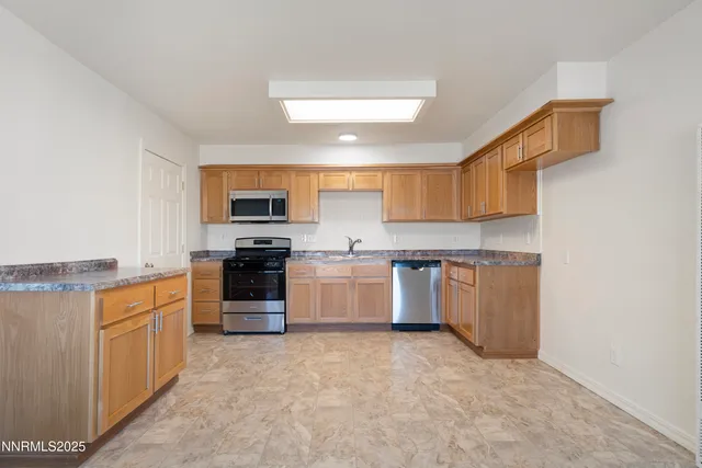 a large kitchen with cabinets and stainless steel appliances