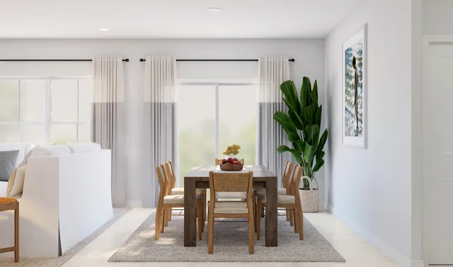 a dining room with furniture and a potted plant