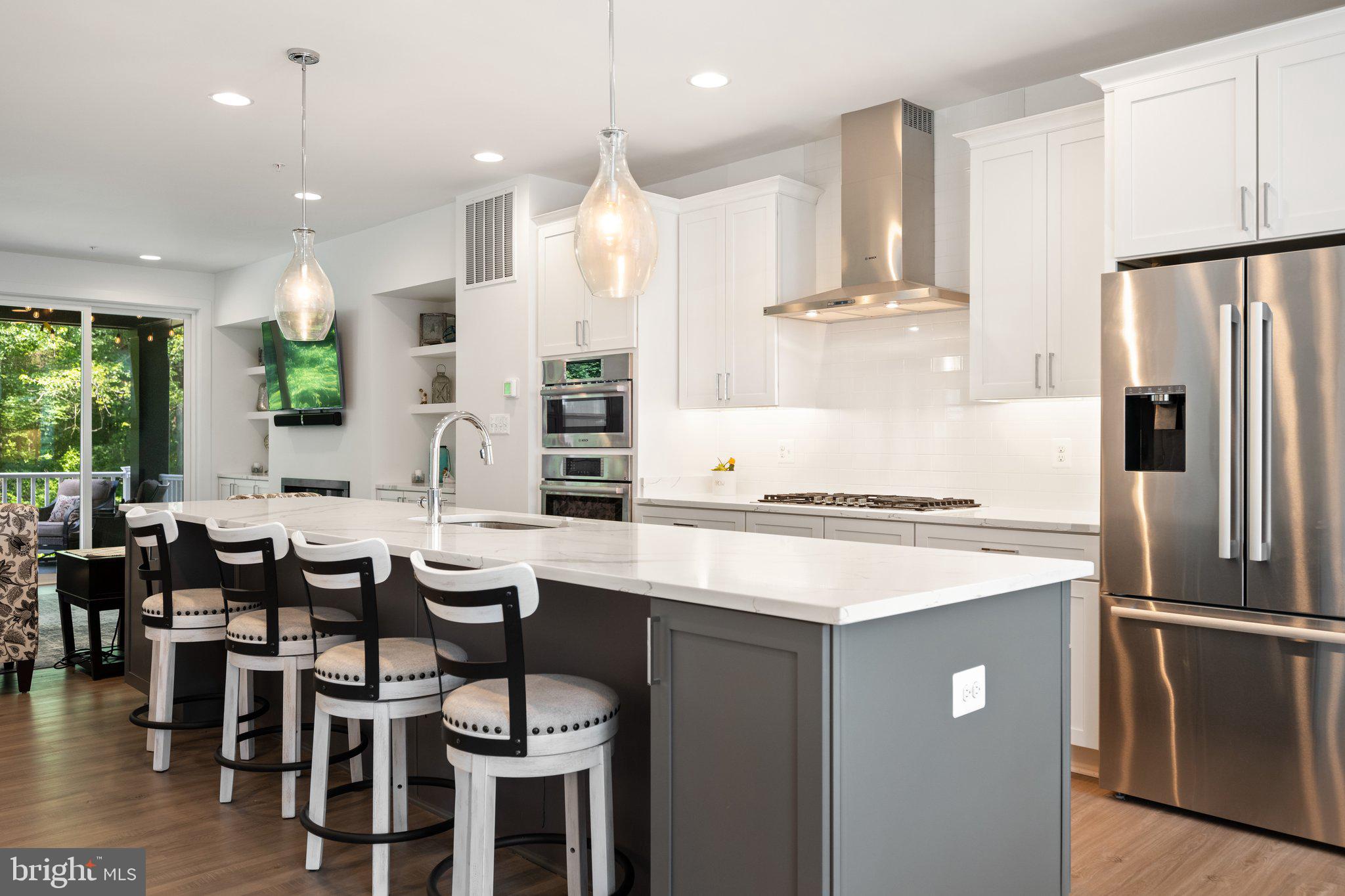 302 Alluvium Drive Laurel, MD 20724 - Photo 6 of 66 a kitchen with stainless steel appliances kitchen island a table chairs sink and cabinets