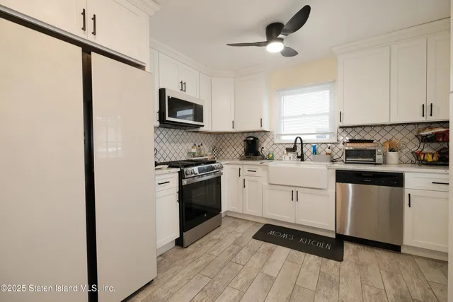 a kitchen with white cabinets stainless steel appliances and sink