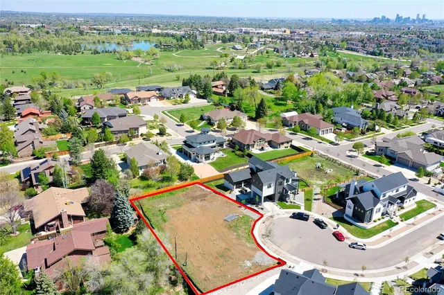 an aerial view of residential houses with outdoor space and parking