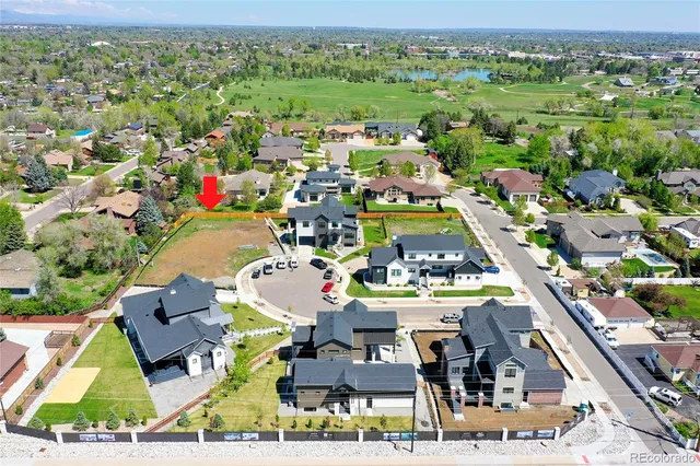 an aerial view of residential houses with outdoor space and parking