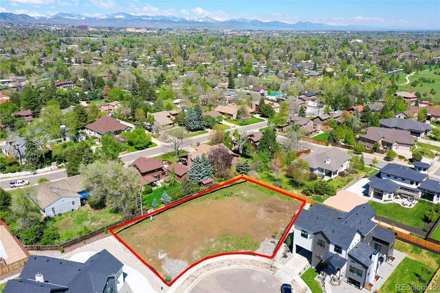 an aerial view of residential houses with outdoor space and trees