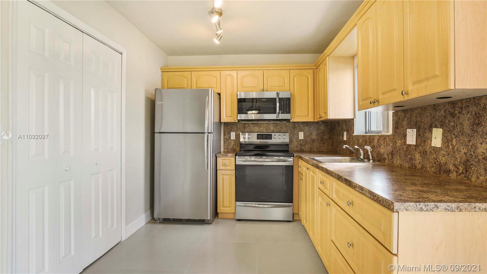 1270 Southeast 26th Street, Unit 101 Homestead, FL 33035 - Photo 2 of 12 a kitchen with stainless steel appliances granite countertop a refrigerator a stove and a sink
