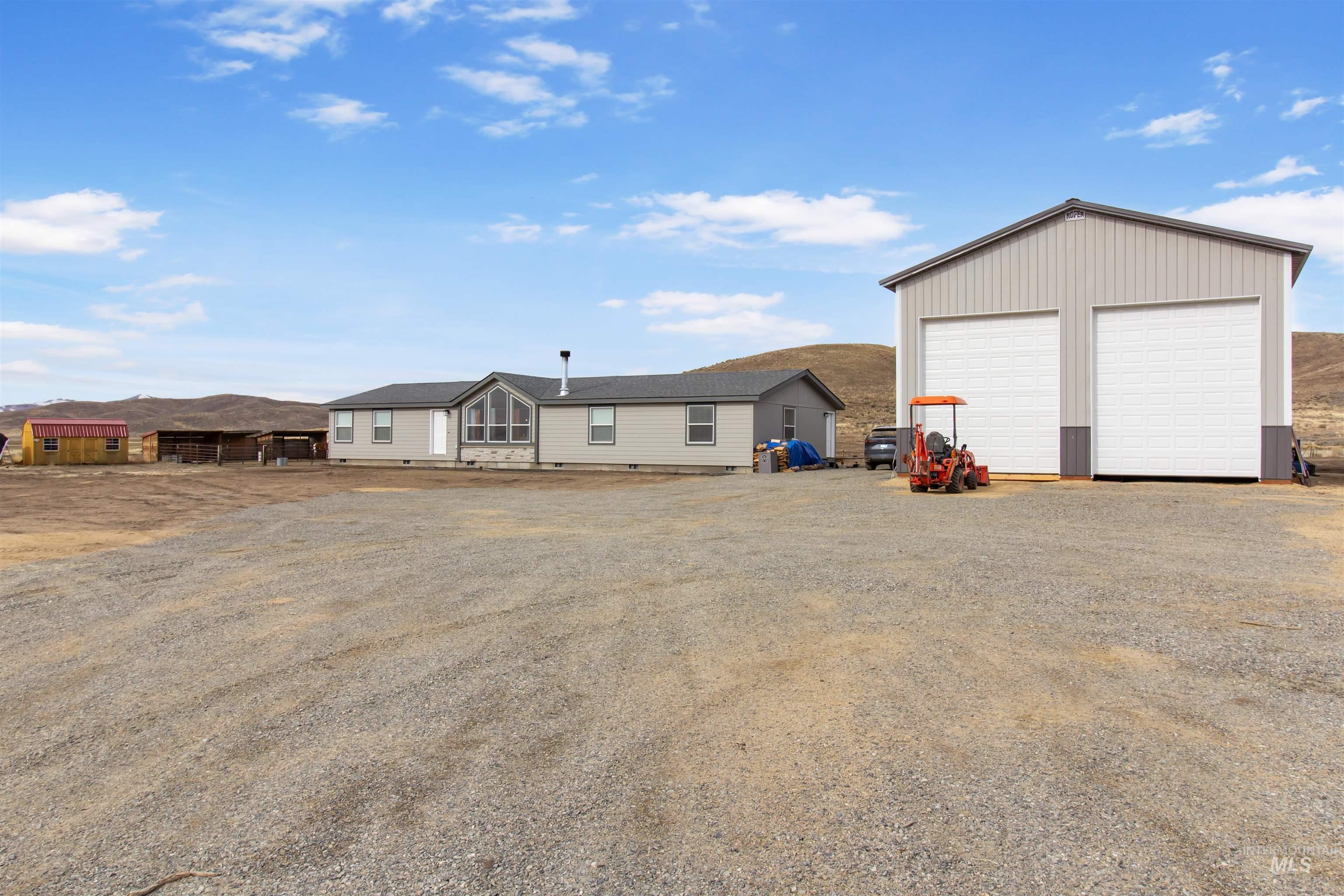 Back of property featuring a detached garage, an outdoor structure, and crawl space