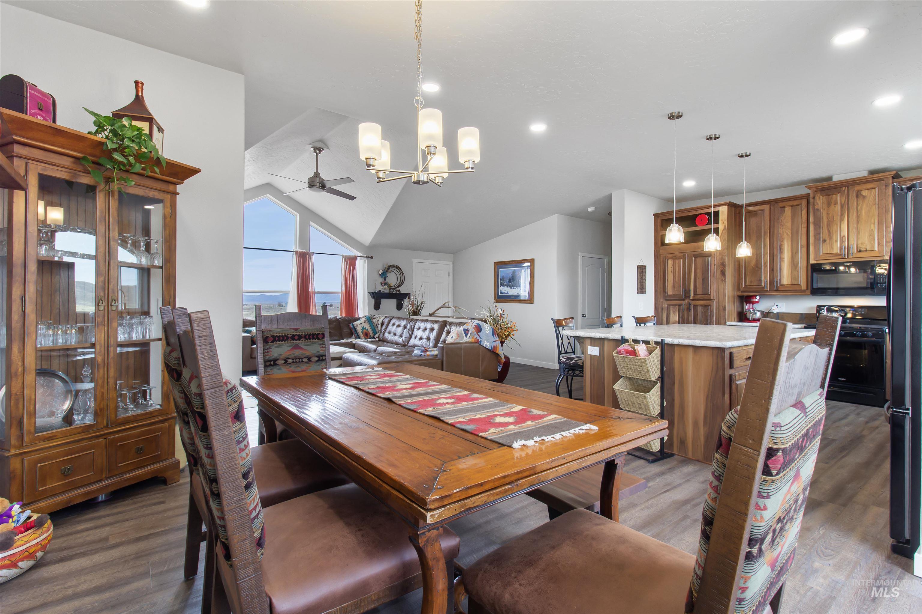 161 Horseshoe Loop West Fairfield, ID 83327 - Photo 13 of 50 Dining space featuring ceiling fan, dark wood-style floors, lofted ceiling, and a chandelier