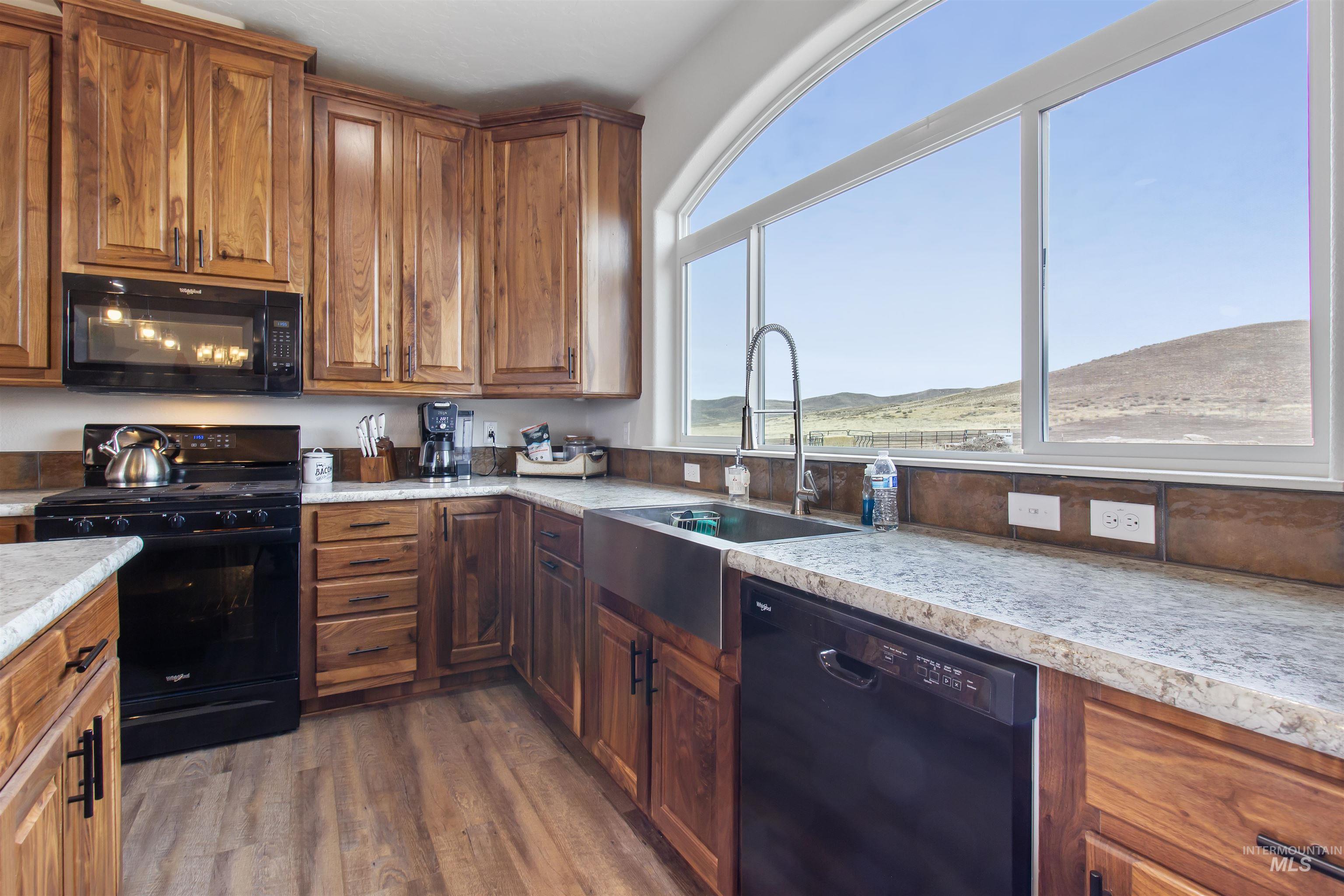 161 Horseshoe Loop West Fairfield, ID 83327 - Photo 16 of 50 Kitchen featuring black appliances, wood finish cabinetry, light countertops, and dark wood-style floors