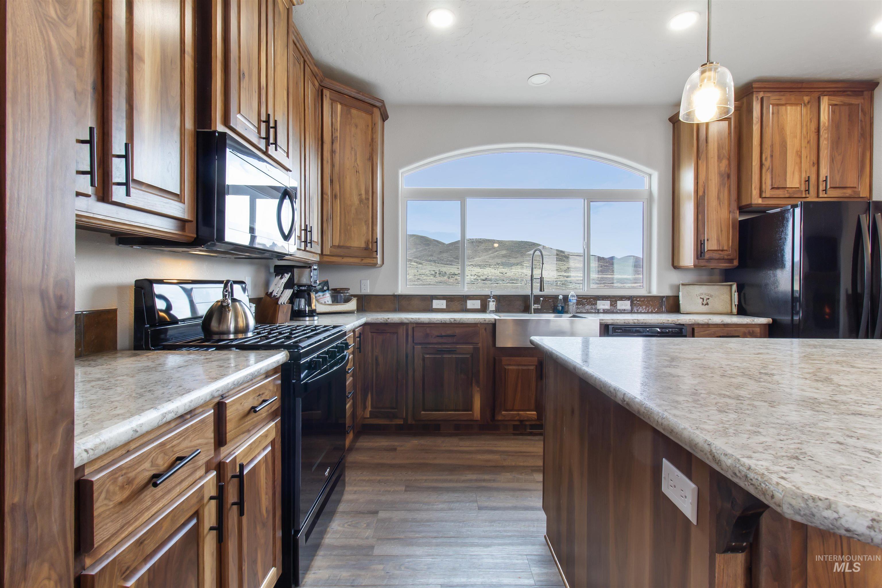 161 Horseshoe Loop West Fairfield, ID 83327 - Photo 18 of 50 Kitchen with black appliances, light countertops, and wood finish cabinets