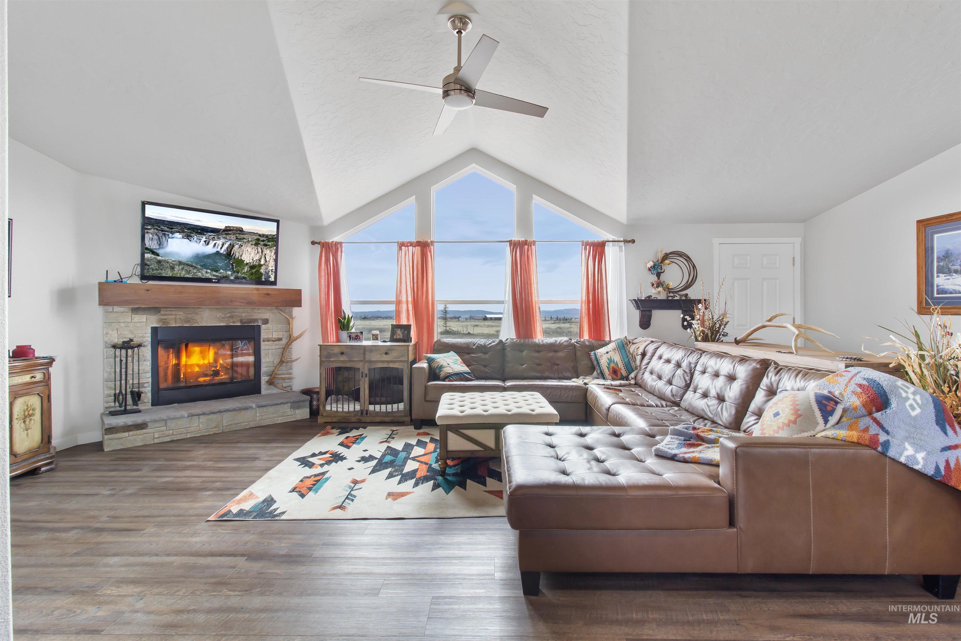 161 Horseshoe Loop West Fairfield, ID 83327 - Photo 23 of 50 Living area with lofted ceiling, a fireplace, wood finished floors, and ceiling fan