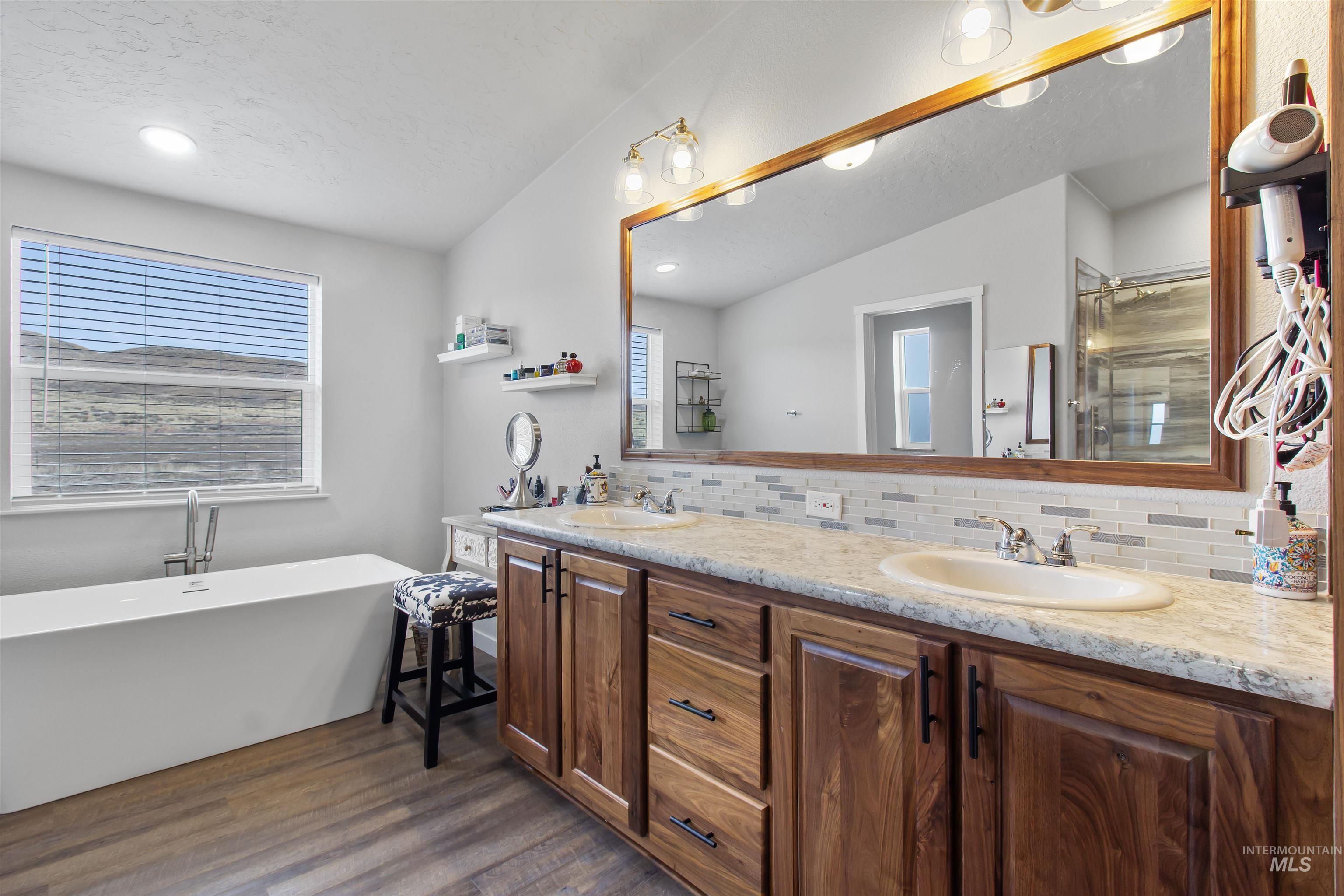 161 Horseshoe Loop West Fairfield, ID 83327 - Photo 31 of 50 Full bath featuring double vanity, a freestanding bath, decorative backsplash, a shower with shower door, and recessed lighting