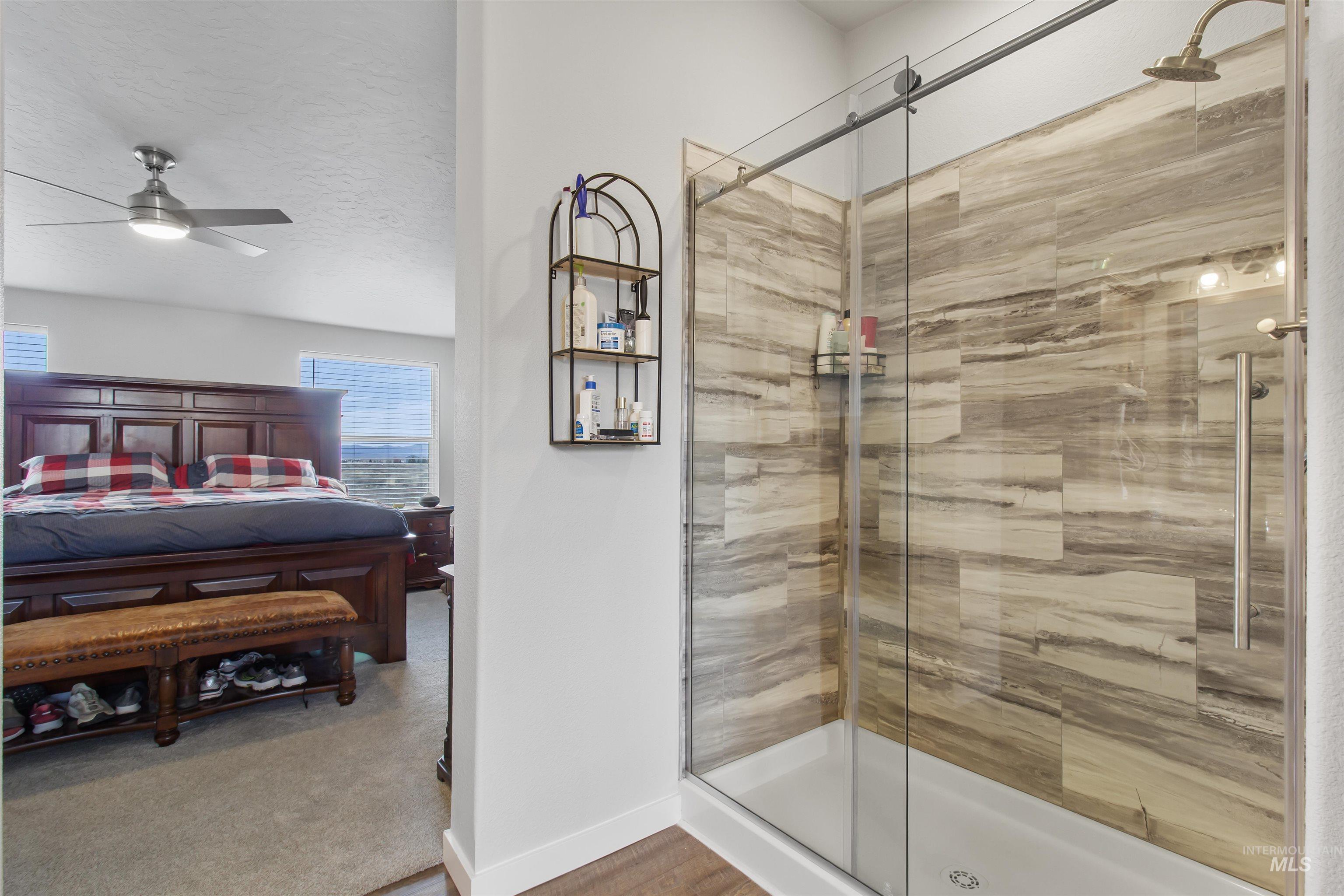 161 Horseshoe Loop West Fairfield, ID 83327 - Photo 32 of 50 Ensuite bathroom featuring a shower stall, a ceiling fan, a textured ceiling, and light colored carpet