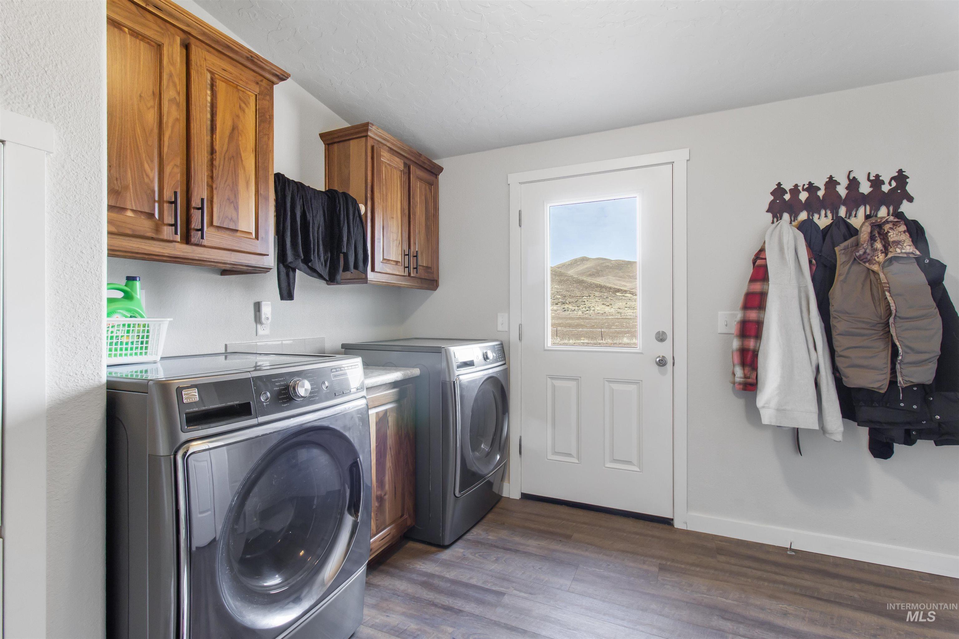 161 Horseshoe Loop West Fairfield, ID 83327 - Photo 40 of 50 Laundry area with dark wood-style floors, washing machine and dryer, and cabinet space