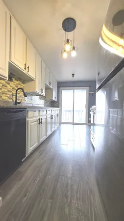 a open kitchen with stainless steel appliances granite countertop a stove top oven a refrigerator with wooden floors and cabinets