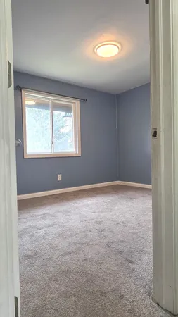 an empty room with a window and closet