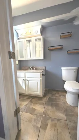 a bathroom with a stove a sink and a vanity