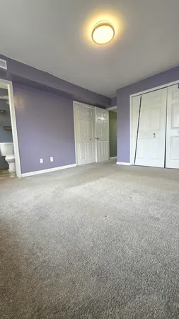 an empty room with windows and closet