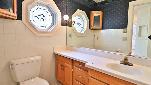 a bathroom with a toilet sink and mirror
