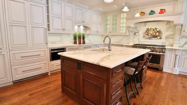 a kitchen with wooden cabinets and center island with chairs