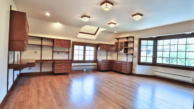 a view of a patio with a dining table and chairs under an umbrella with a small yard