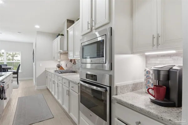 a kitchen with stainless steel appliances kitchen island granite countertop a sink stove and cabinets