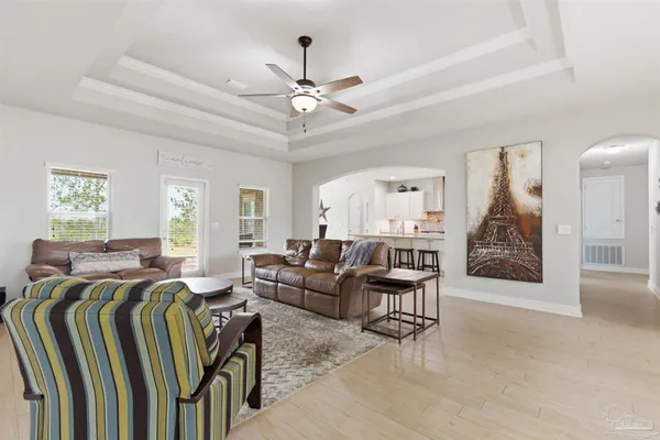 a living room with furniture a chandelier and a flat screen tv