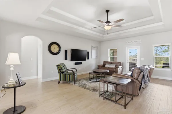 a living room with furniture a flat screen tv and a window