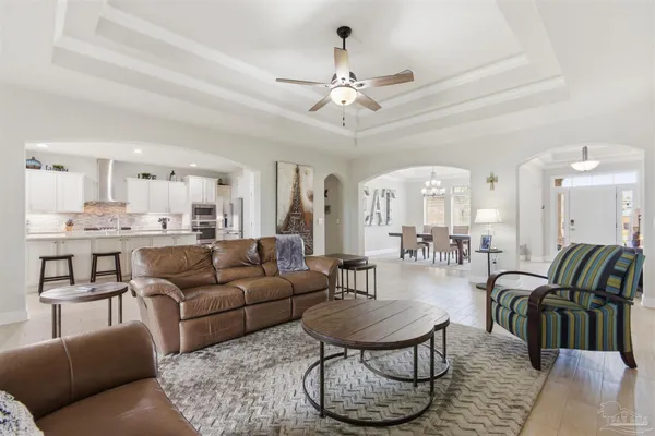 a living room with furniture kitchen and a chandelier