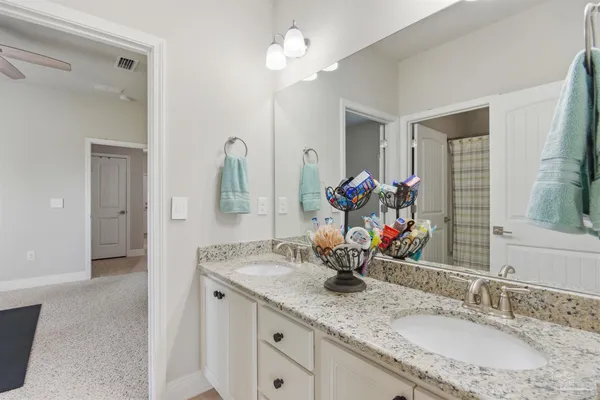 a bathroom with a granite countertop sink a large mirror and a window