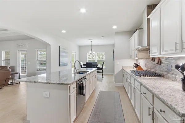 a large kitchen with stainless steel appliances granite countertop a lot of counter space and a sink