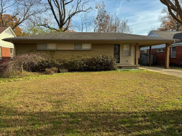a view of house with yard and outdoor seating