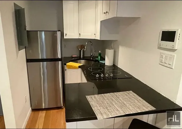 a kitchen with stainless steel appliances granite countertop a refrigerator and a stove
