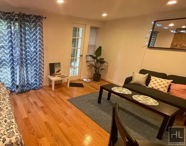 a living room with furniture and a wooden floor