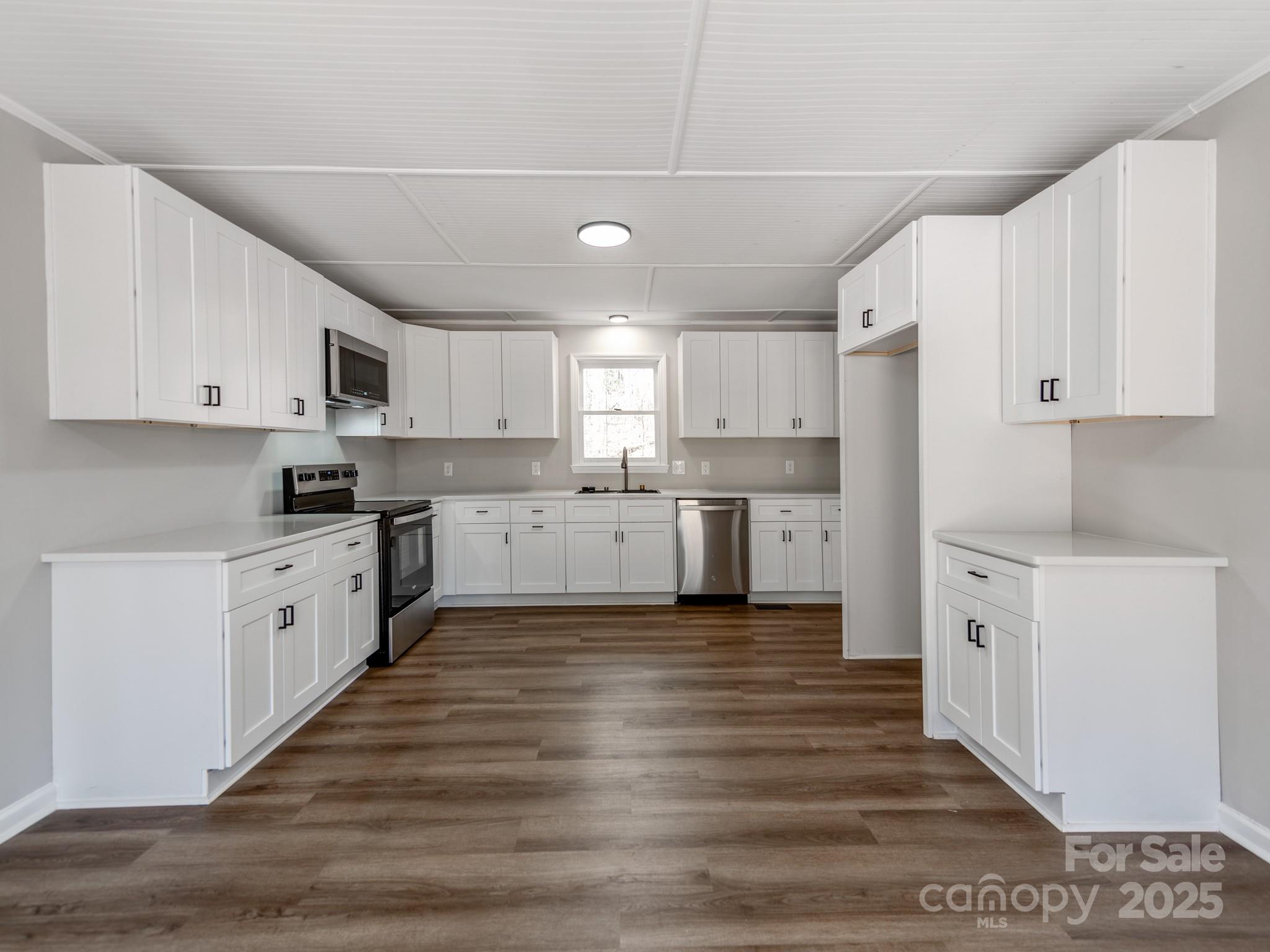 107 Rutledge Road Mount Holly, NC 28120 - Photo 7 of 26 a large kitchen with cabinets and wooden floor
