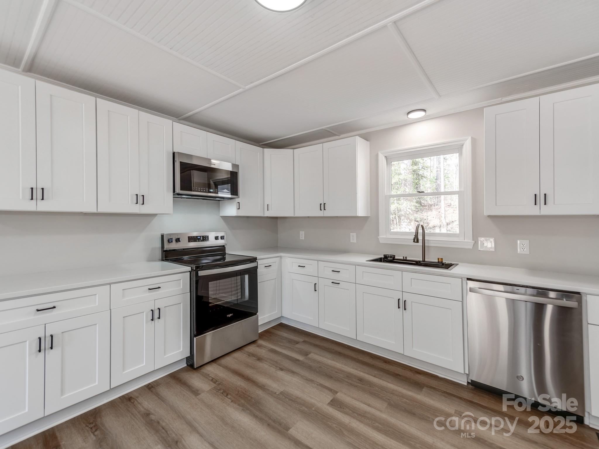 107 Rutledge Road Mount Holly, NC 28120 - Photo 8 of 26 a kitchen with granite countertop white cabinets and white appliances