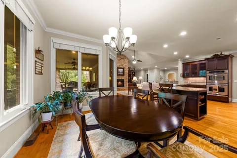 a dining room with furniture a large window and wooden floor