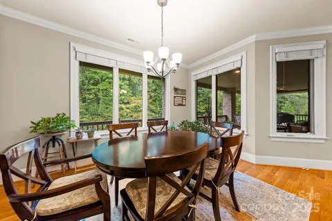 a dining room with furniture a chandelier and wooden floor