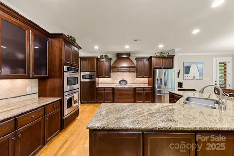 a kitchen with stainless steel appliances granite countertop a sink a stove and a refrigerator
