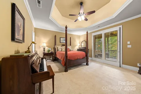 a spacious bedroom with a bed a chandelier and large window