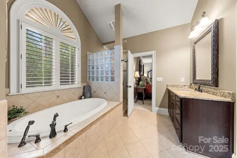 a spacious bathroom with a tub sink and mirror