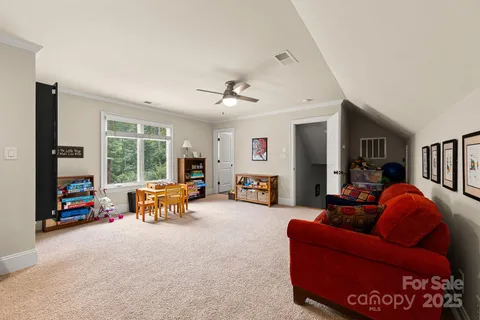 a living room with furniture a flat screen tv and a floor to ceiling window