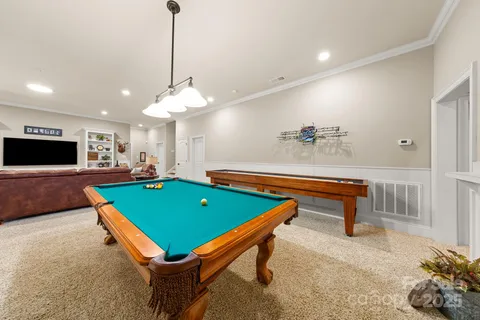 a room with pool table and windows