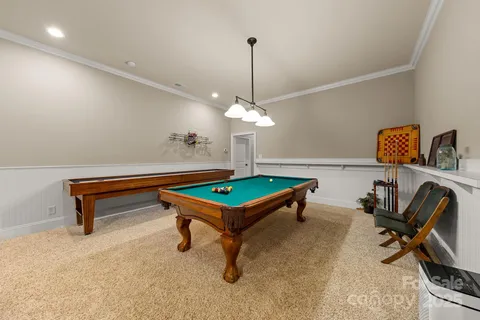 a room with pool table and windows