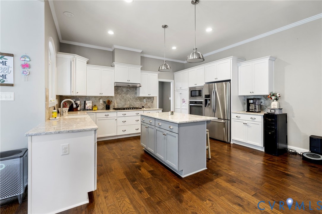 16507 Hannington Drive Midlothian, VA 23112 - Photo 14 of 43 a kitchen with stainless steel appliances a refrigerator a sink dishwasher a stove top oven a kitchen island and chairs with wooden floor